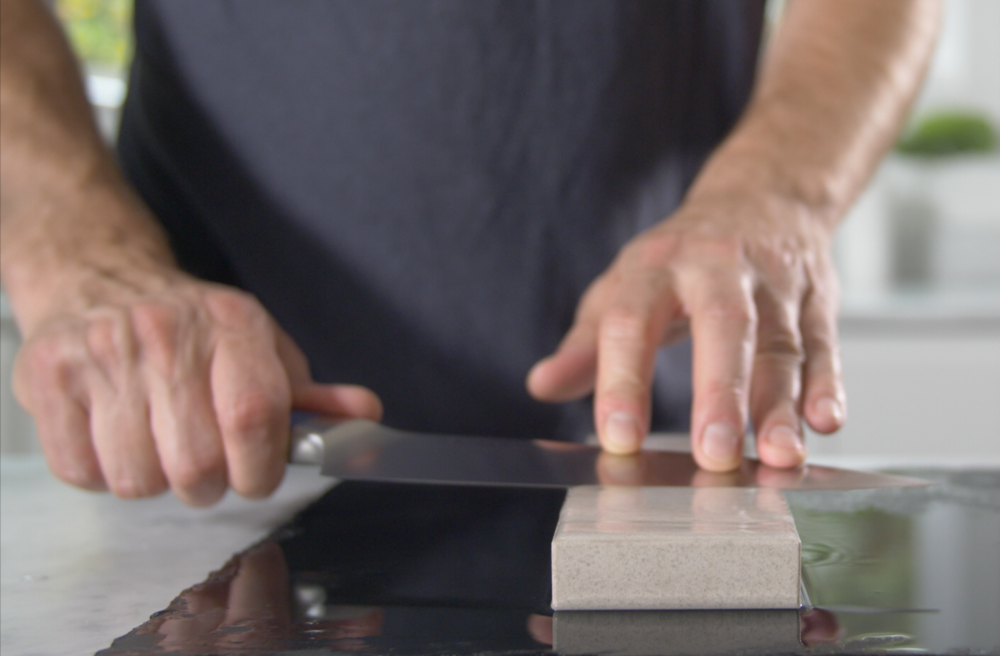 Sharpening stone: A man sharpens a knife