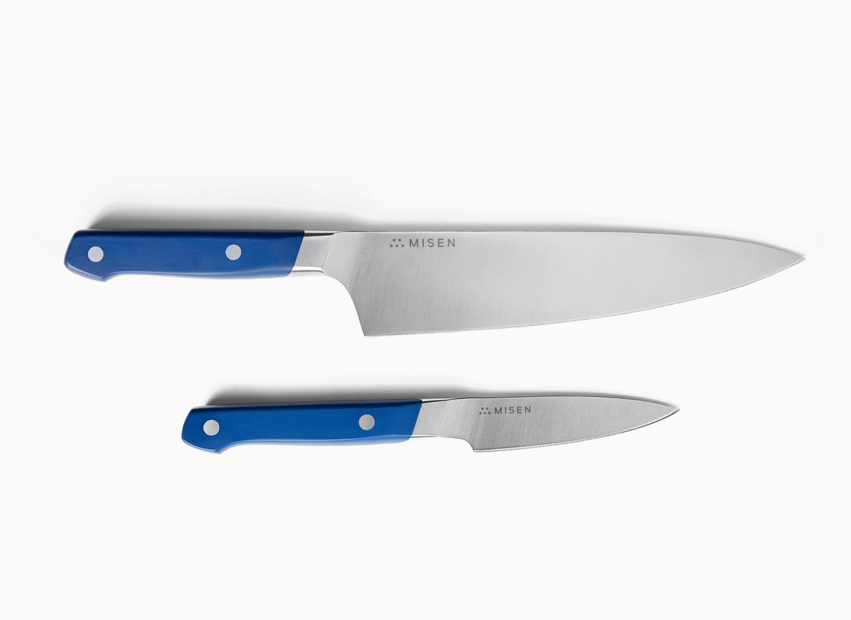 A top-down view of two blue-handled knives against a plain white background. The larger knife, an 8 inch Chef's Knife 2.0, is positioned above the smaller knife, a 3.5 inch Paring Knife 2.0. Both knives have silver-toned ACUT0440 steel blades with the word "MISEN" and a logo engraved on them. The handles are a vibrant blue, each with two silver rivets visible.
