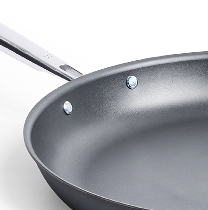 Hard anodized nonstick frying pan with stainless steel riveted handle close-up