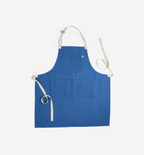 Blue linen bib apron with adjustable neck strap and cream canvas ties