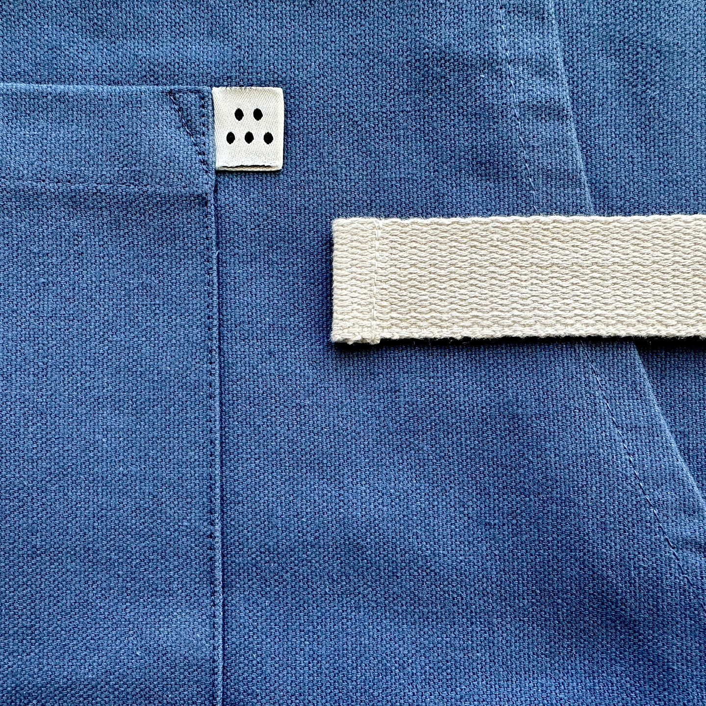 Blue linen trousers back detail with white canvas belt loop and care label