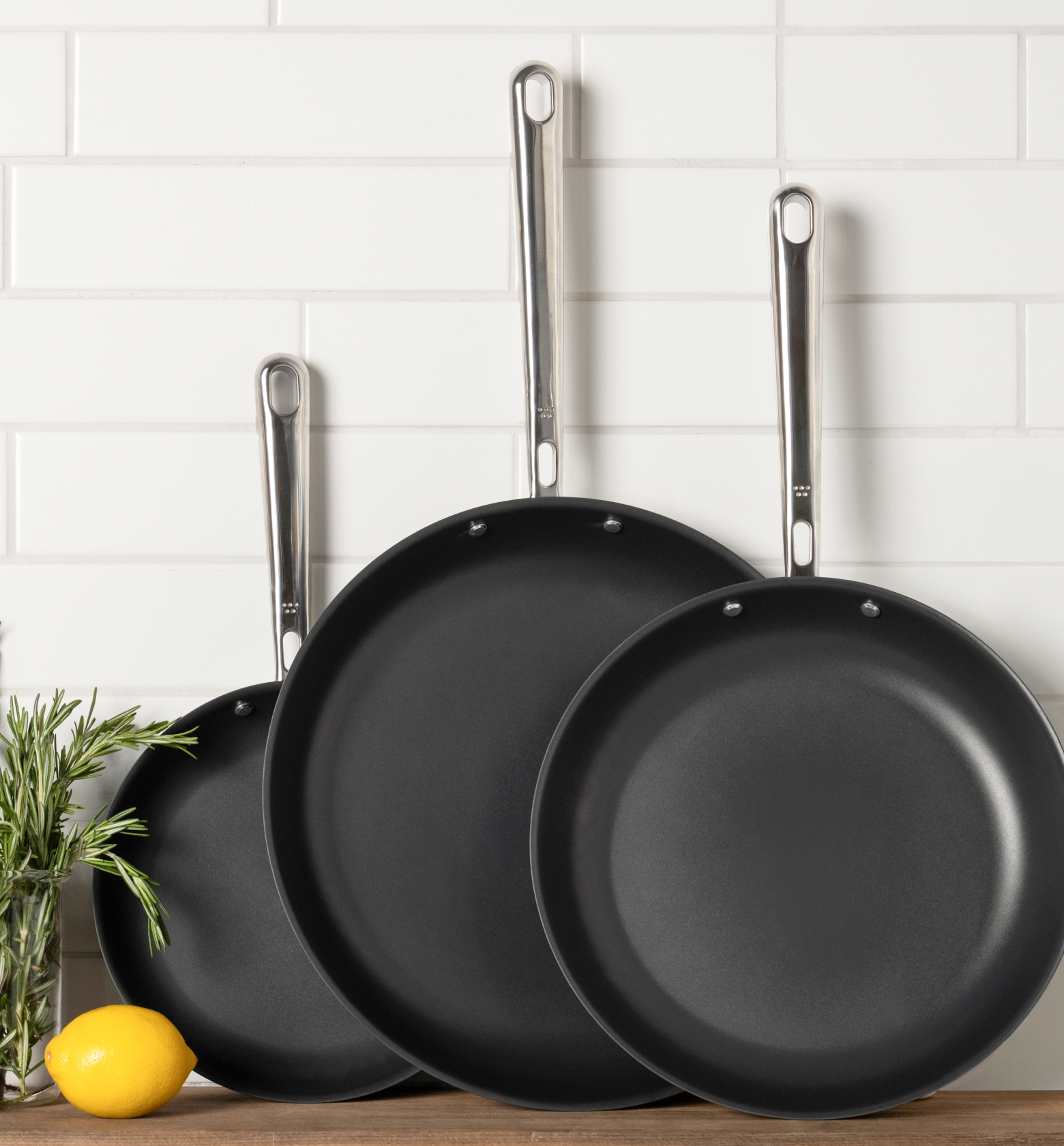 Three-piece nonstick frying pan set with stainless steel handles on kitchen counter