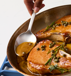 Pan-seared pork chops with capers, rosemary, and golden pan sauce in skillet