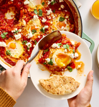 Shakshuka with feta cheese and fresh herbs served in a cast iron skillet