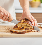 Misen bread knife slicing rustic sourdough loaf on wooden cutting board