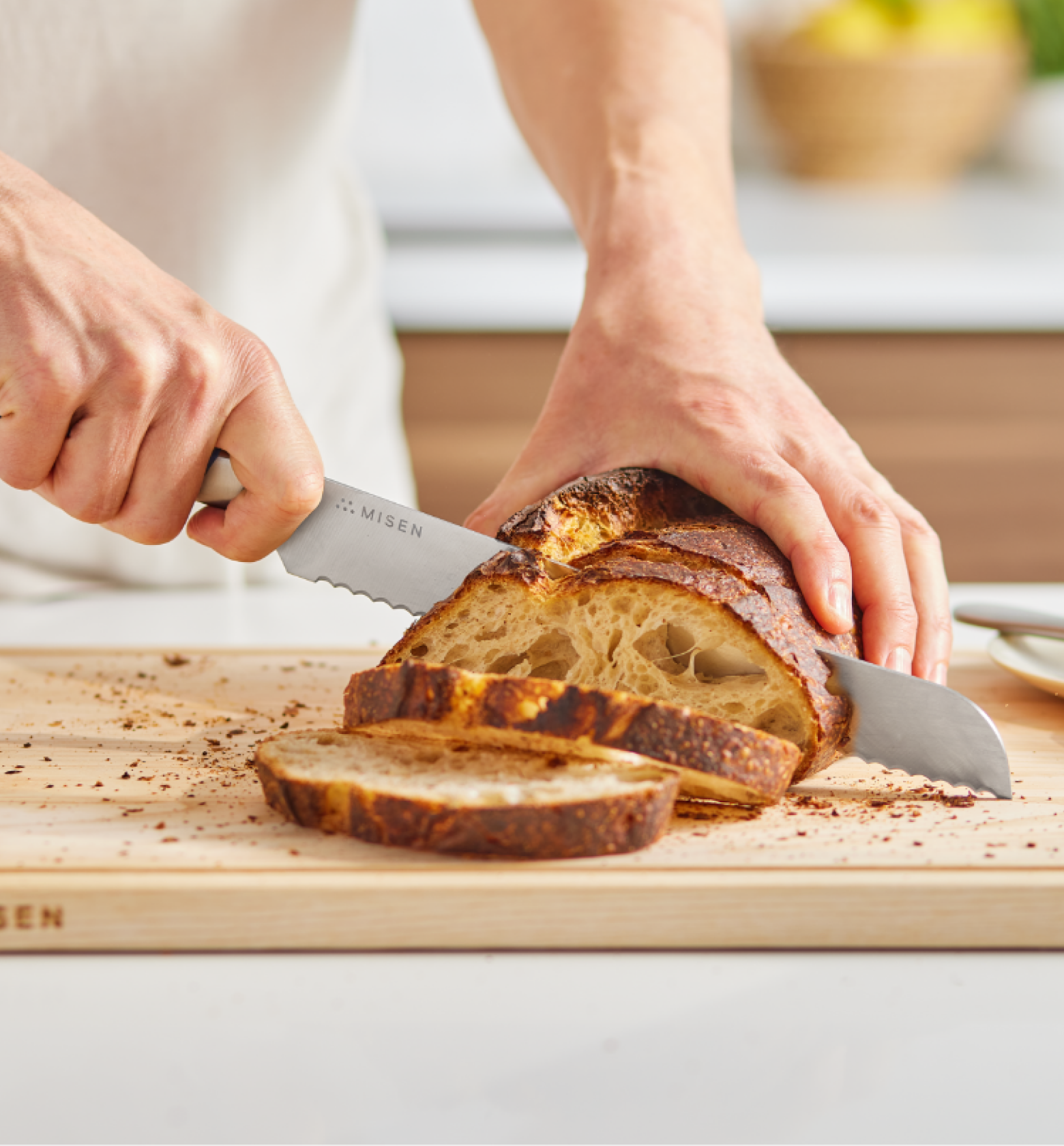 Misen bread knife slicing rustic sourdough loaf on wooden cutting board