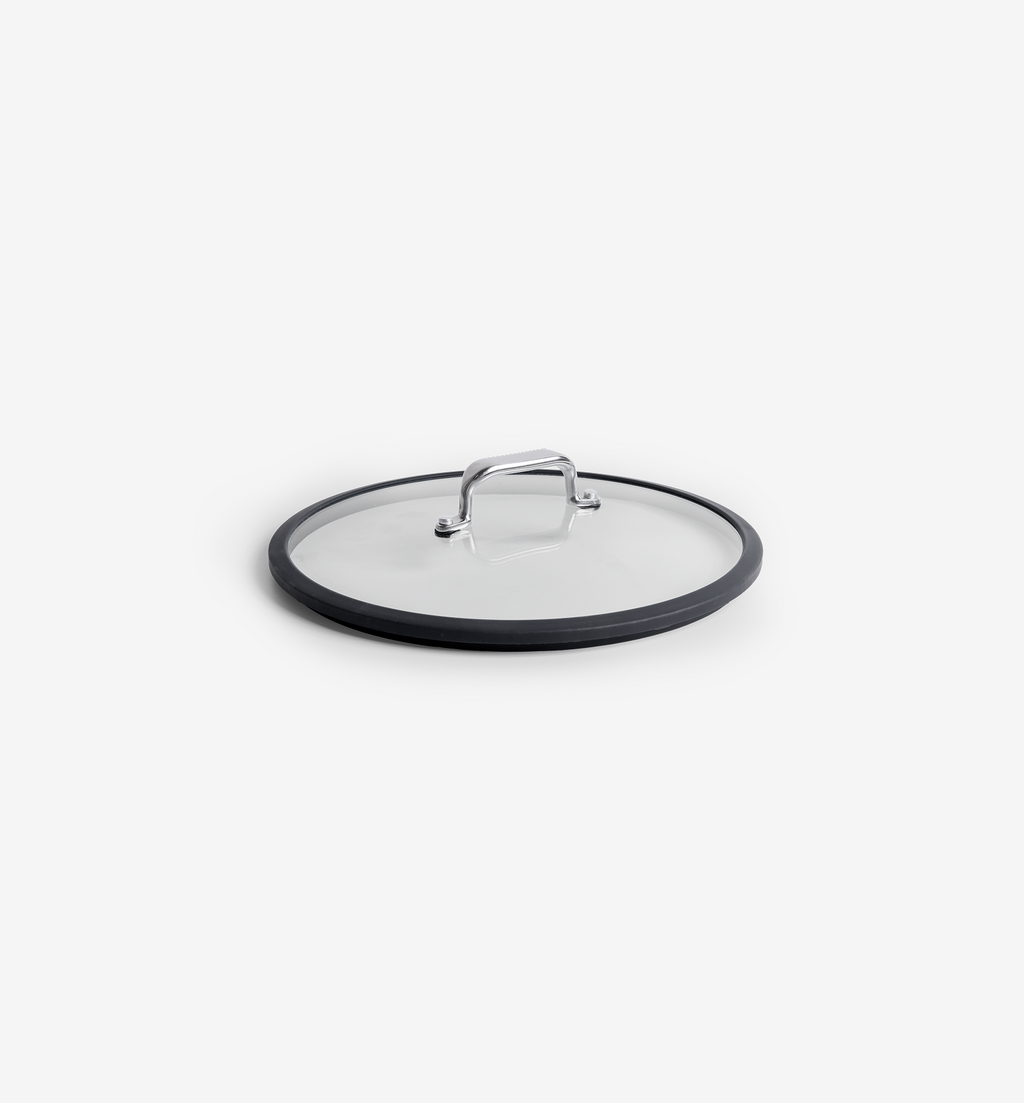 Clear glass pan lid with stainless steel handle and black silicone rim