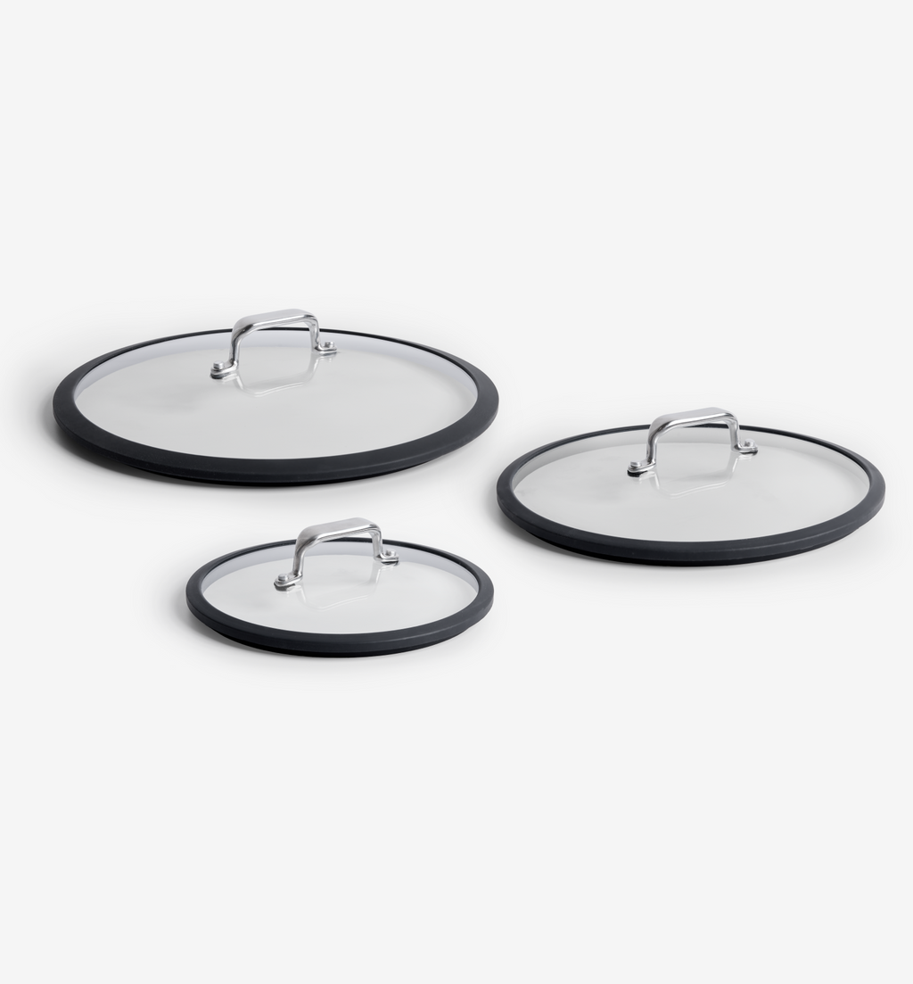 Set of three glass pan lids with silicone rims and stainless steel handles in small, medium, and large sizes