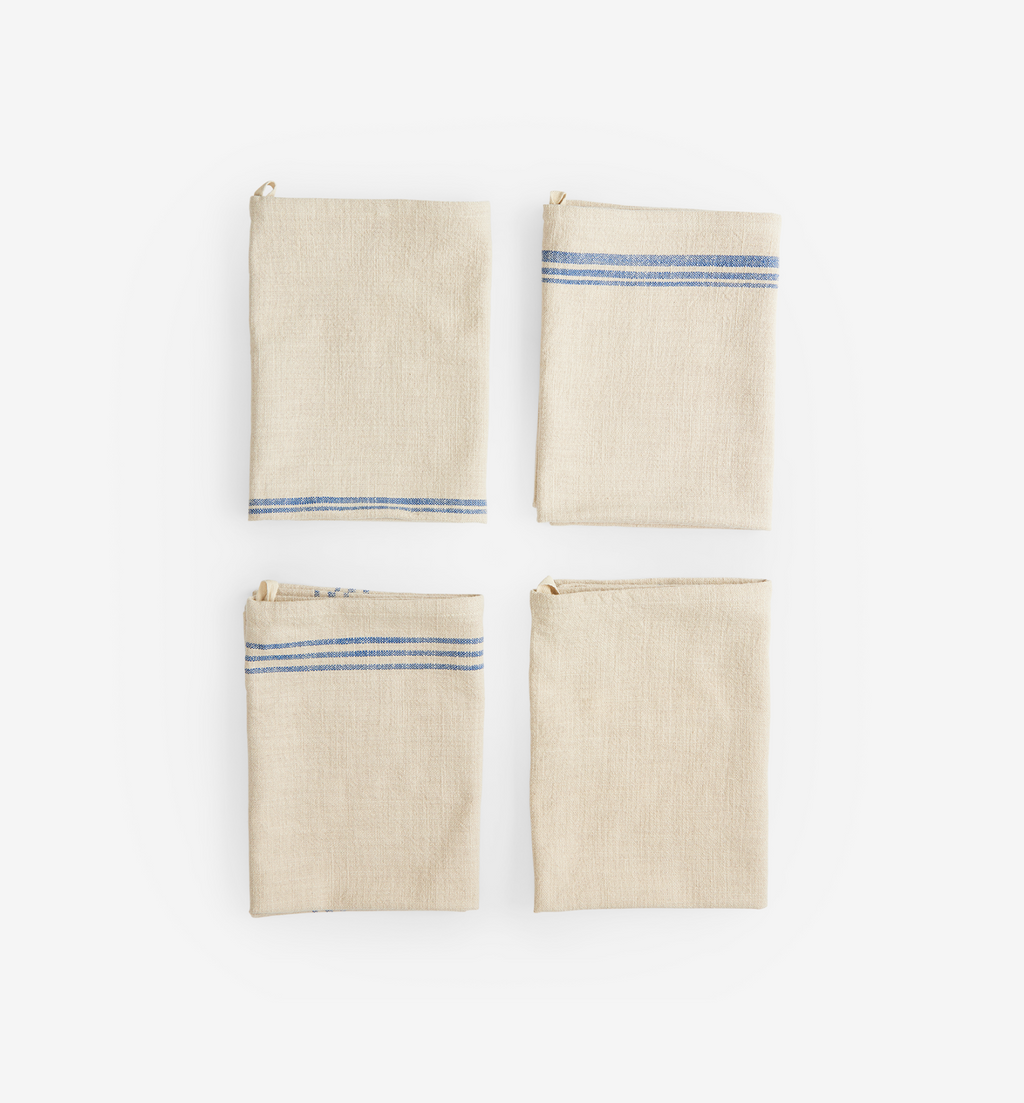 Set of four folded linen kitchen towels with blue stripe detail