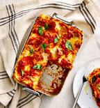 Homemade lasagna in Misen baking pan with tomato sauce and fresh basil