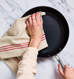 Drying a nonstick frying pan with a linen dish towel