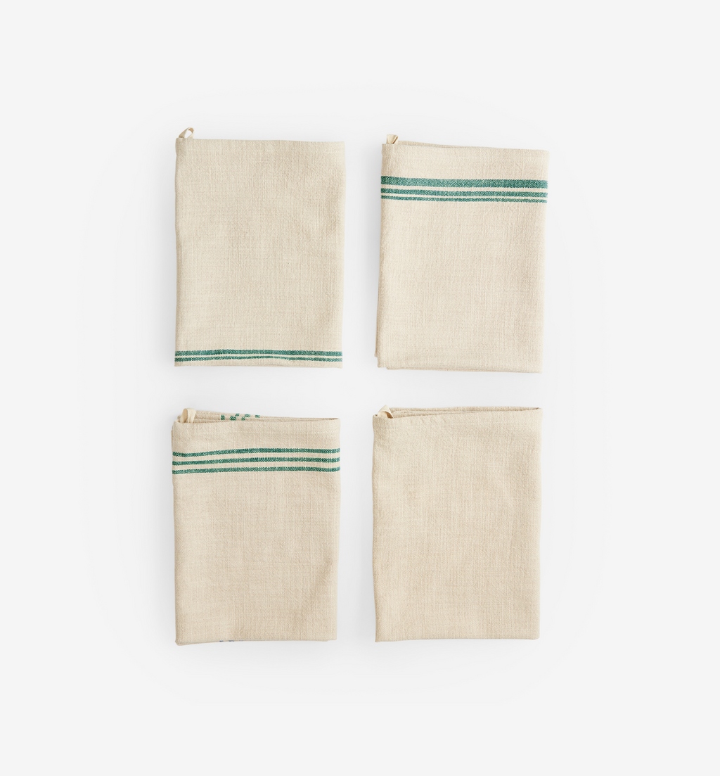 Set of 4 natural linen kitchen towels with green stripe detail, folded flat lay