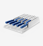 Kitchen knife set with blue handles stored in white drawer organizer block