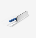 Kitchen knife with blue handle resting in white countertop knife storage dock