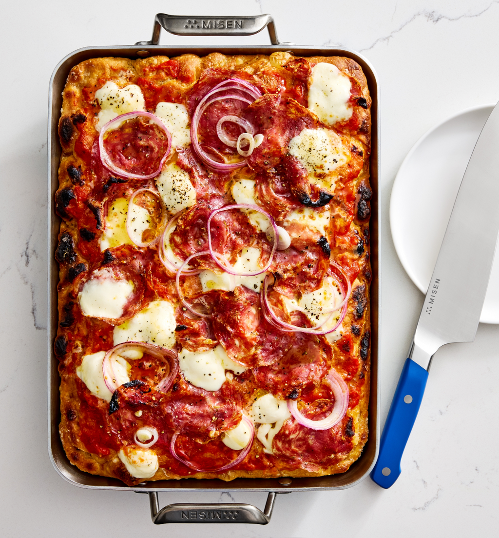 Detroit-style sheet pan pizza with mozzarella, salami, and red onion in Misen baking pan