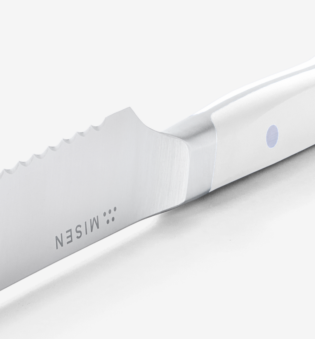 Misen steak knife close-up showing serrated blade and white handle