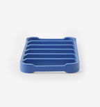 Blue silicone soap dish with ribbed drainage channels and non-slip feet