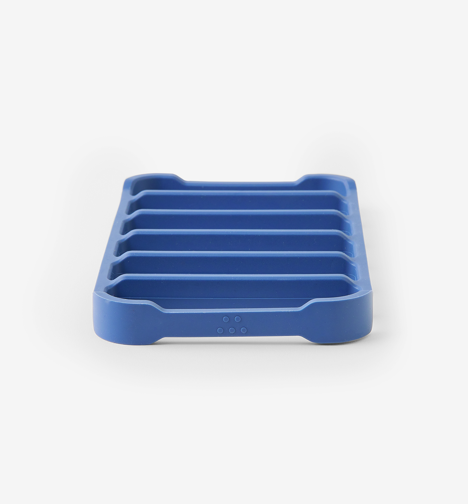 Blue silicone soap dish with ribbed drainage channels and non-slip feet