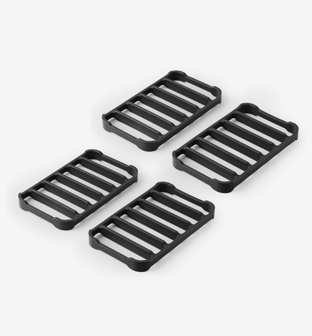 Set of 4 black cast iron trivets with slatted grill pattern