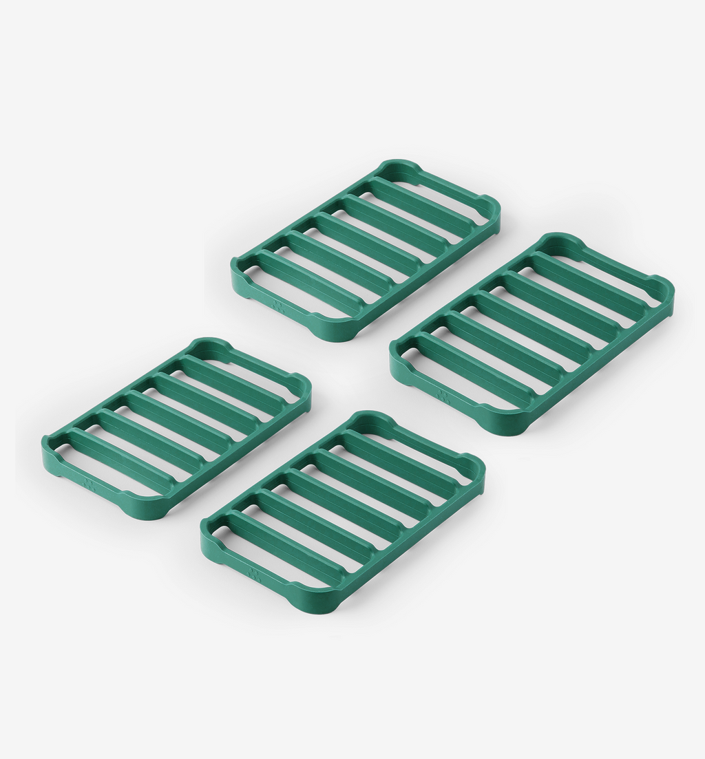 Set of 4 green silicone trivets with slatted design for heat protection