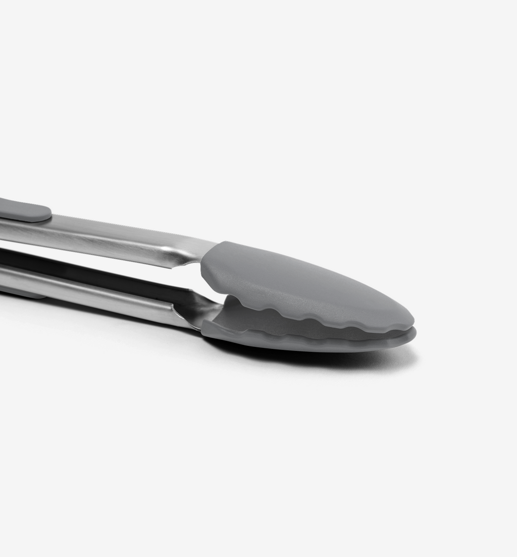 Stainless steel kitchen tongs with gray silicone tips close-up