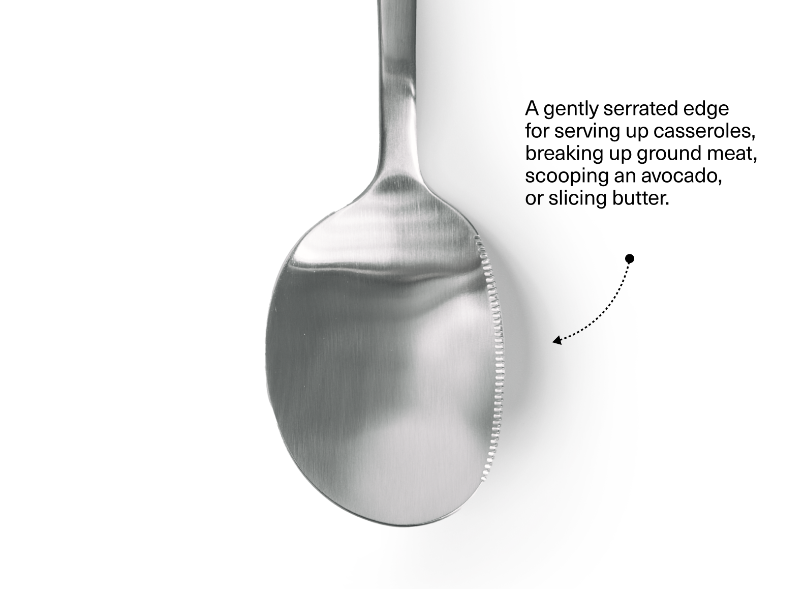 The image shows the oval-shaped bowl of a stainless steel serving spoon, positioned vertically against a white background. The spoon bowl has a matte or brushed finish with serrations along the right half of its rim. To the right of the spoon, there is text that reads: "A gently serrated edge for serving up casseroles, breaking up ground meat, scooping an avocado, or slicing butter." Below the text, a dotted line with an arrow points towards the serrated edge of the spoon bowl.
