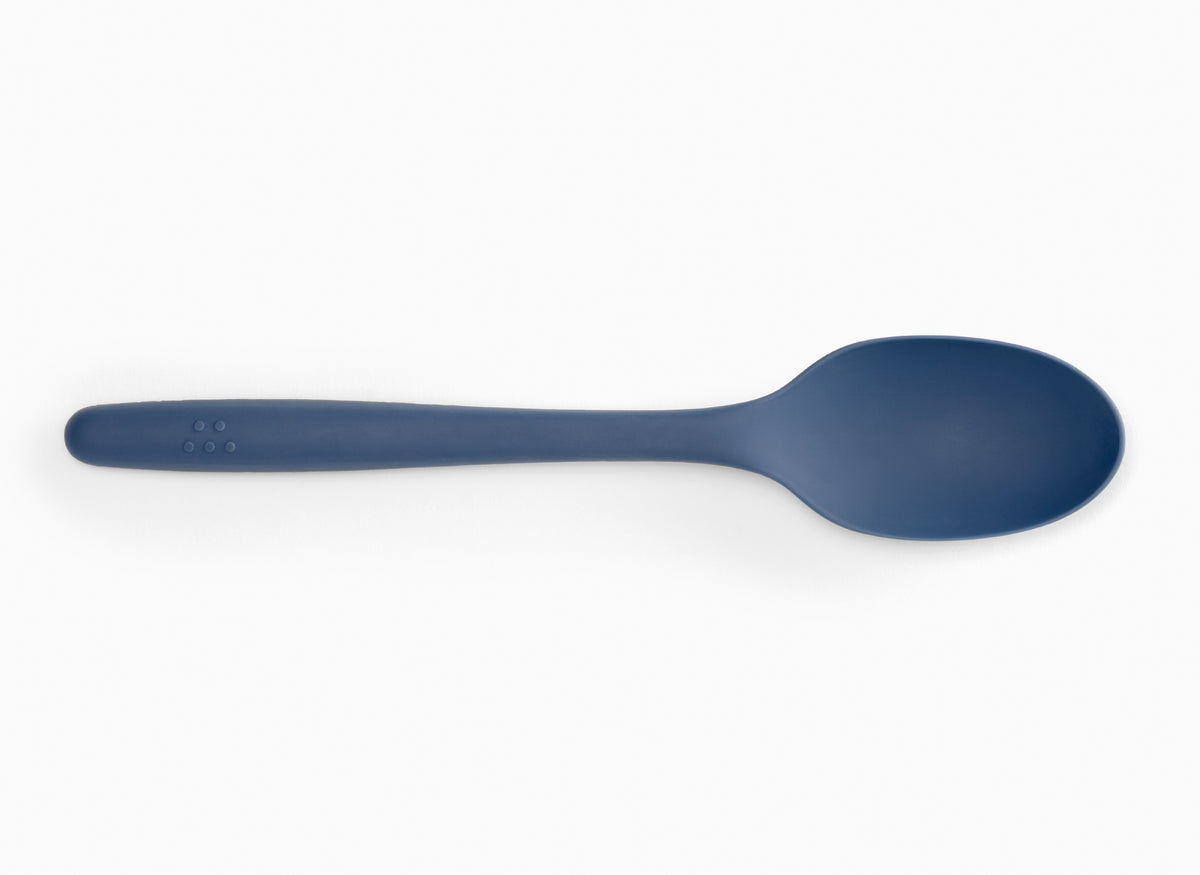 A blue silicone mixing spoon on a white background.