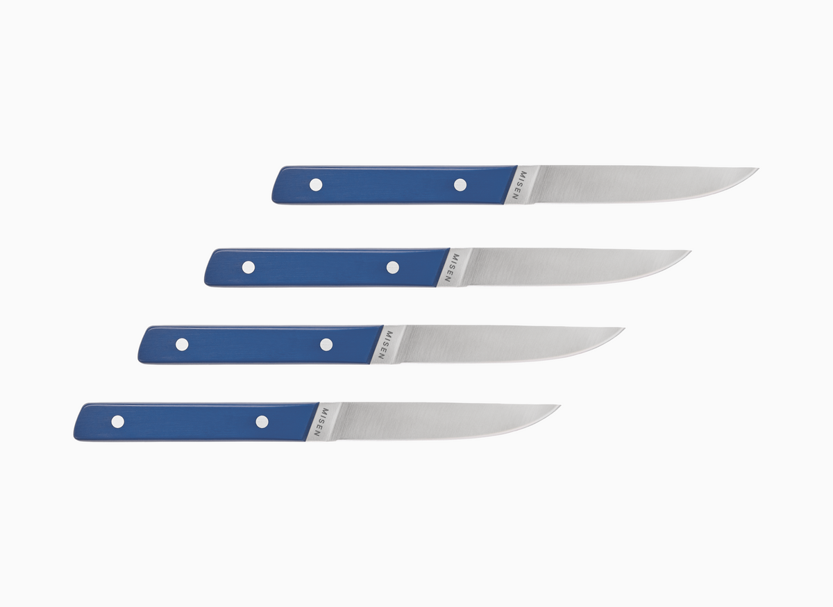 Set of four straight edge Misen ACUTO steak knives with blue handles on a white background