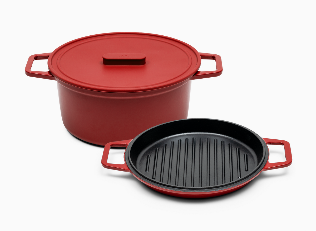 A red Dutch oven with a silicone lid and a detachable lid that has a grill pan.