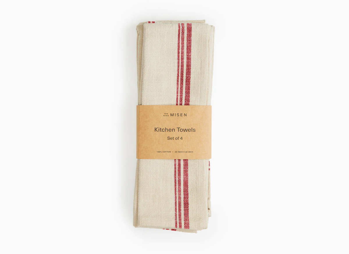 A set of red Misen Kitchen Towels in their packaging lie flat on a white background.